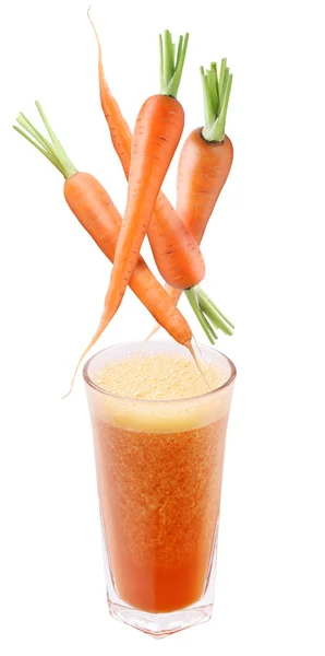 Carrot falling into a glass of fresh juice. — Stock Photo, Image