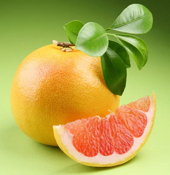 Ripe grapefruit with segment on a green background — Stock Photo, Image