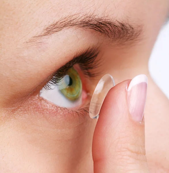 Menschliches Auge mit Korrekturlinse auf weißem Grund — Stockfoto