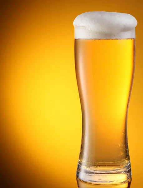 Bicchiere di birra su sfondo giallo — Foto Stock