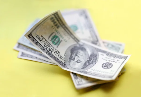 Δολάρια. κάποιο κομμάτι των χρημάτων σε κίτρινο φόντο. — Φωτογραφία Αρχείου