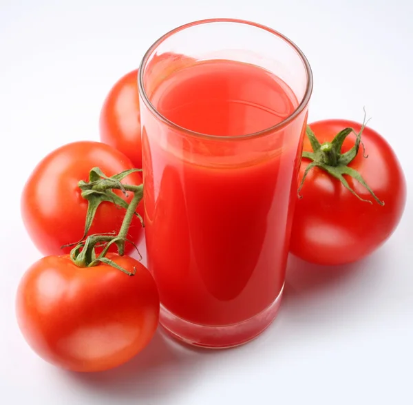 Bardak domates suyu ve üzerinde beyaz izole olgun domates — Stok fotoğraf