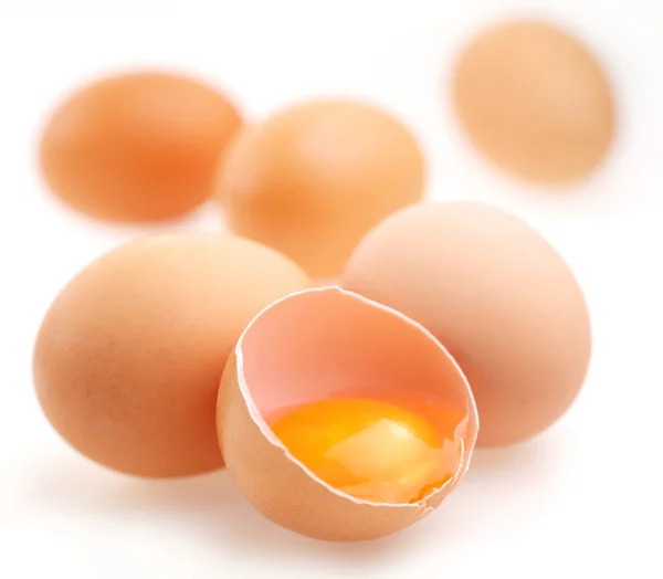 Mit braunen Eiern auf weißem Hintergrund. Ein Ei ist zerbrochen. — Stockfoto