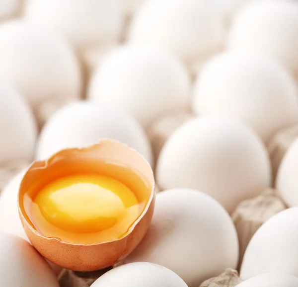 Разбитое коричневое яйцо среди яиц . — стоковое фото