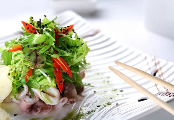 Salade met eruca en octopus op een witte plaat — Stockfoto