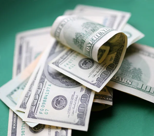 Dólares. Un poco de dinero sobre fondo verde . — Foto de Stock