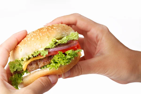 Le mani tengono un cheeseburger su uno sfondo bianco — Foto Stock