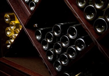 Snapshot of the wine cellar. The bottles on wooden shelves.