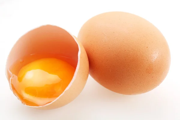 Z brązowe jaja na białym tle. jedno jajko jest uszkodzony. — Zdjęcie stockowe