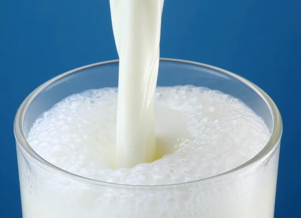 Glass of milk on a blue background — Stock Photo, Image