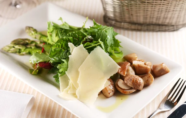Ensalada con champiñones porcini y rúcula en un plato blanco —  Fotos de Stock