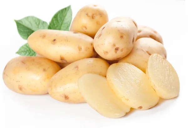 Batatas amarelas com folhas em um fundo branco — Fotografia de Stock