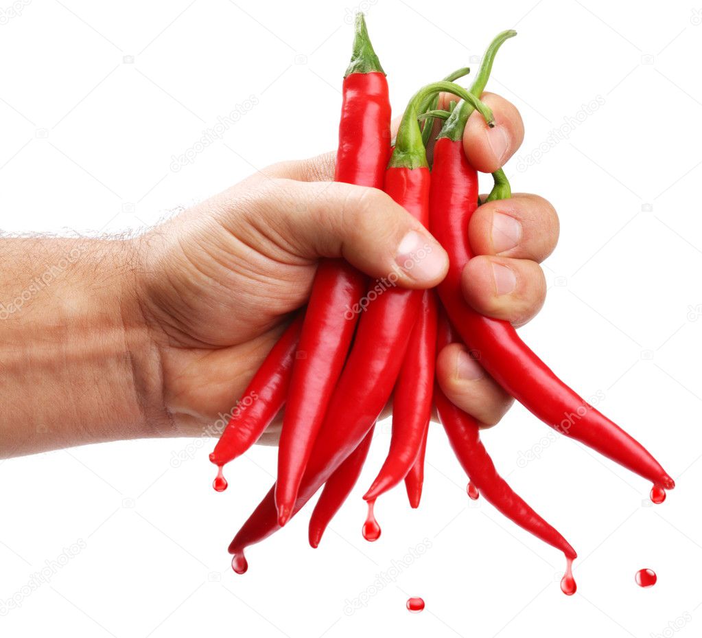 Hand squeezes the juice from red chilli