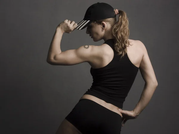 Das Mädchen der Sportler im Studio auf grauem Hintergrund — Stockfoto