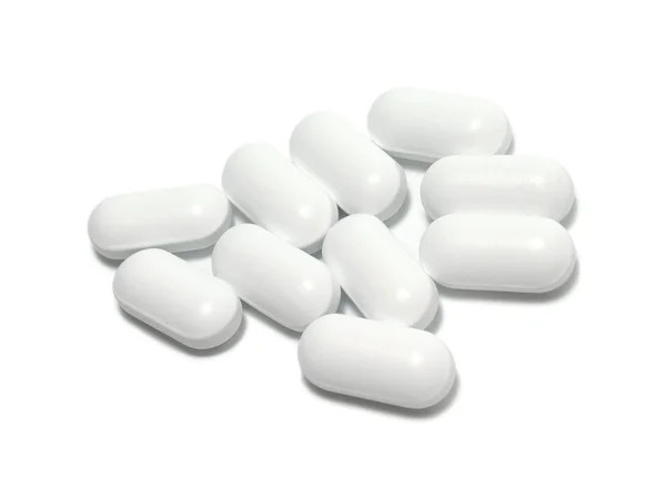 Белые таблетки на белом фоне — стоковое фото