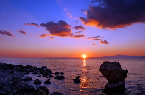 Zachód słońca nad kamienistą plażą — Zdjęcie stockowe