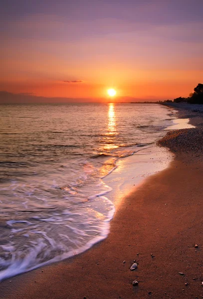 Elhagyatott tengerparton naplementekor Stock Fotó