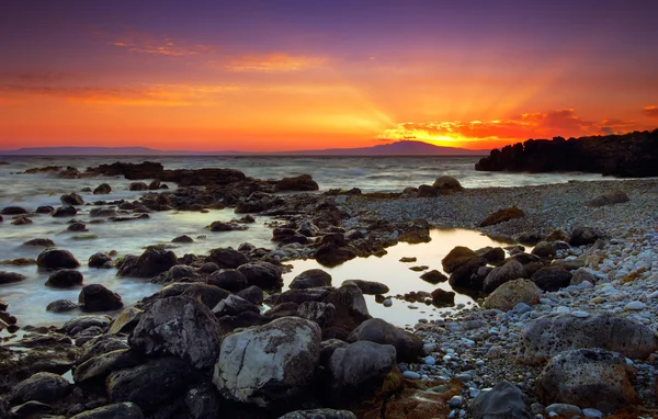 Glorioso pôr-do-sol sobre o mar rochoso — Fotografia de Stock