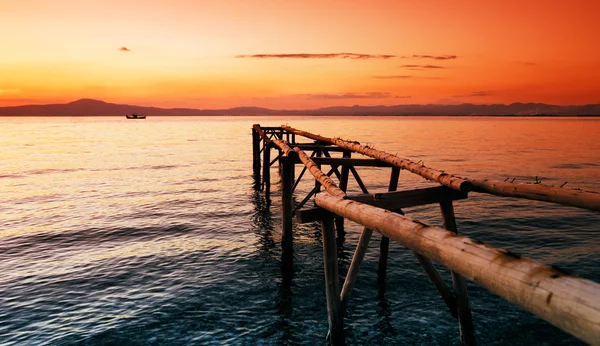 Primitive wooden pier at sunset — Stock Photo, Image