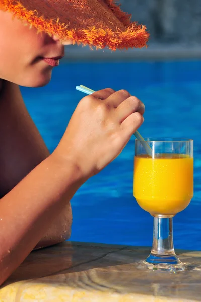 Beautiful woman ready to enjoy orange juice by the pool — Stock Photo, Image