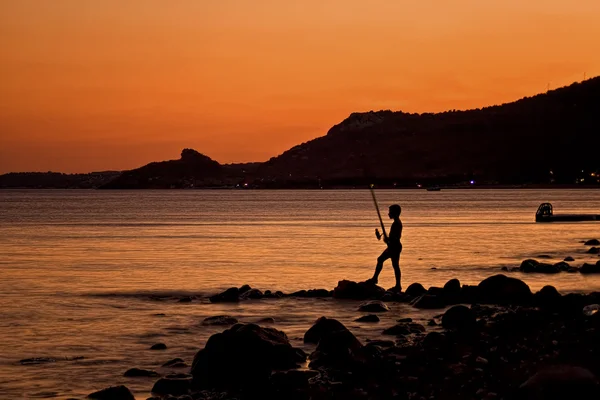 Pescatore solitario al tramonto — Foto Stock