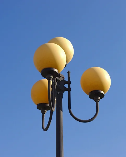 Lâmpada de rua em dia ensolarado em um fundo azul céu — Fotografia de Stock