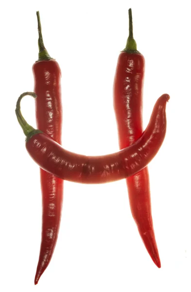 "H "γράμμα από πιπεριές τσίλι σε λευκό φόντο — Φωτογραφία Αρχείου