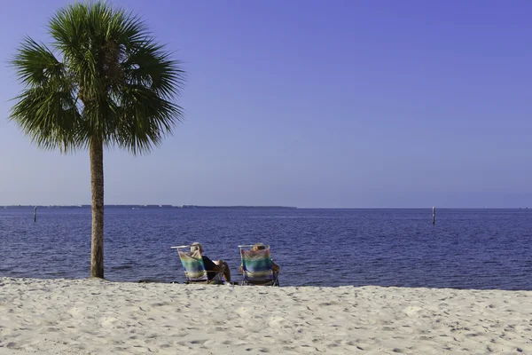 Starsze pary relaks na plaży — Zdjęcie stockowe