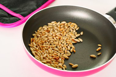 Toasted pinenuts in pan clipart