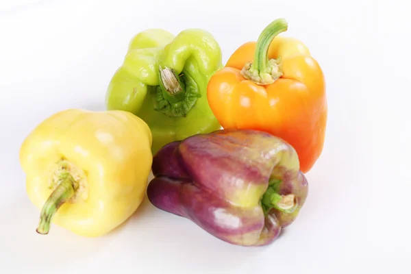 Různé barevné papriky na bílém pozadí — Stock fotografie