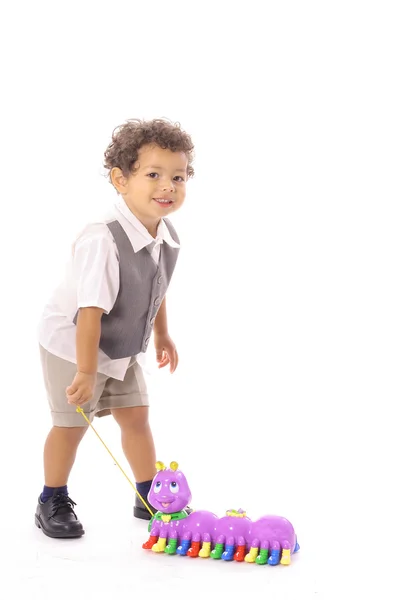Маленький мальчик тянет своего игрушечного катепиллара — стоковое фото