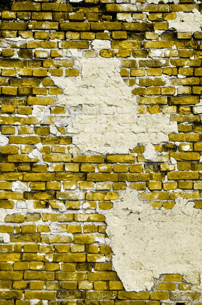 Старая желтая стена с трещинами и пластырями — стоковое фото