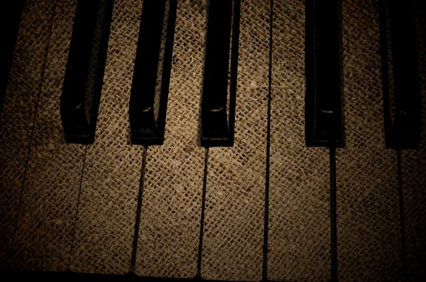 คีย์บอร์ดเปียโนมืดที่มีเนื้อเยื่อกรองจ์ — ภาพถ่ายสต็อก