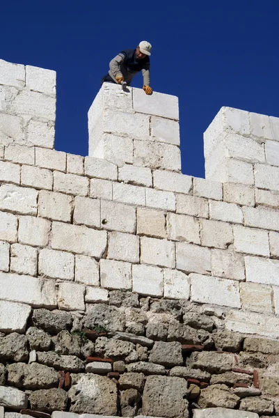 Trabalhador na parede de pedra — Fotografia de Stock