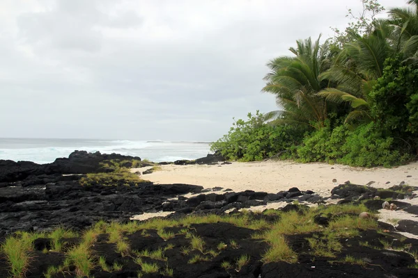 Lava op het zand strand — Stockfoto