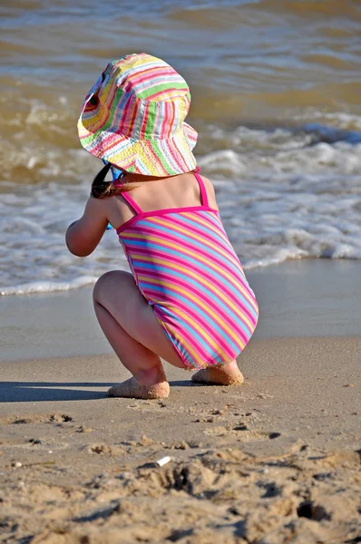 Pequena menina brincando na praia — Fotografia de Stock