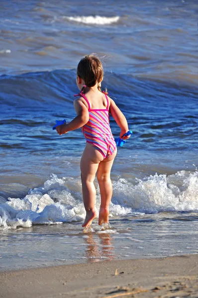 Piccola bambina prescolare che salta tra le onde — Foto Stock