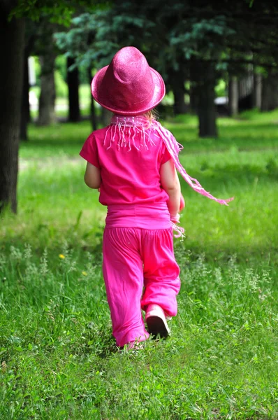 Kleines modisches Mädchen ganz in rosa zu Fuß — Stockfoto