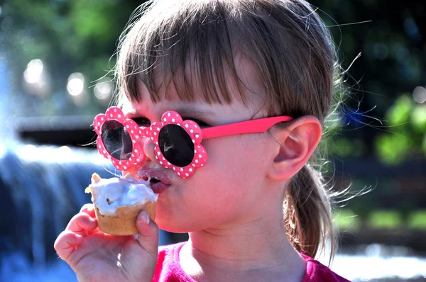 Niña en gafas de sol comiendo helado — Foto de Stock