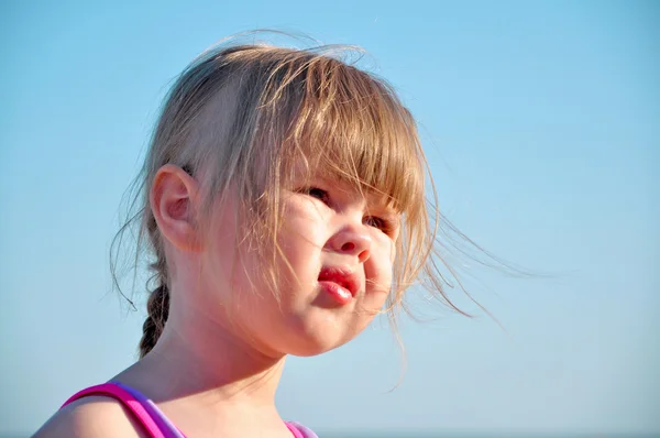The portrait of a little cute girl on the sky background — Stock Photo, Image