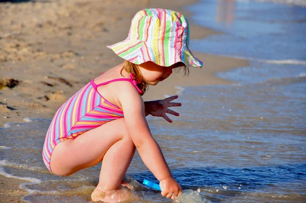 छोटे बच्चे लड़की पोर्ट्रेट चाकू के साथ समुद्र तट पर खेल रहा है — स्टॉक फ़ोटो, इमेज
