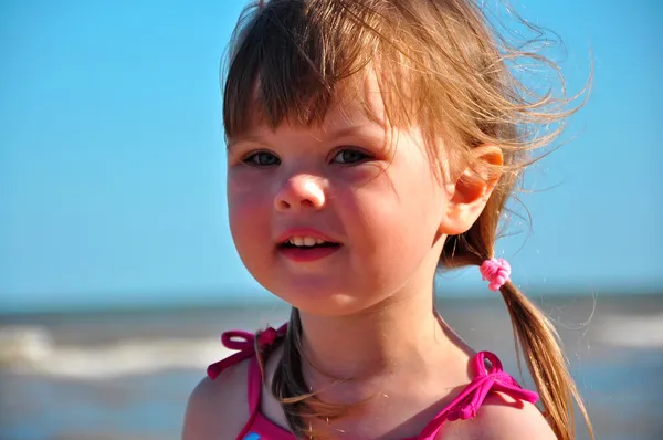 Porträtt av en liten söt flicka på himmel bakgrund — Stockfoto