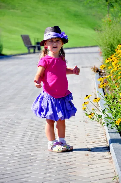 Roztomilá holčička, stojící v parku — Stock fotografie