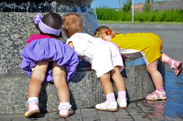 Trzy małe dziewczynki, grając z fontanny wody — Zdjęcie stockowe