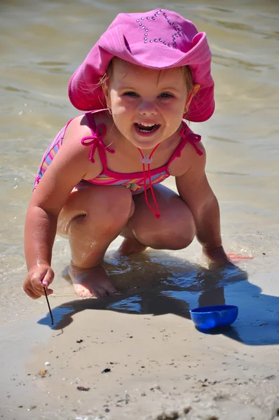 Pequeña niña jugando en la playa — Foto de Stock
