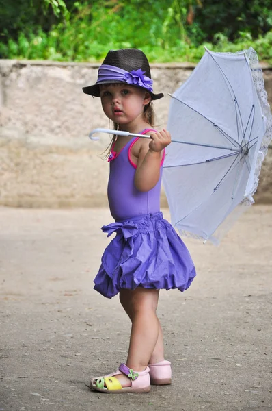 Barn girl med paraply på gatan — Stockfoto