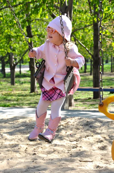 Pretty toddler girl riding on swing — Stock Photo, Image
