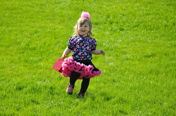 Toddler girl running on green grass — Stock Photo, Image