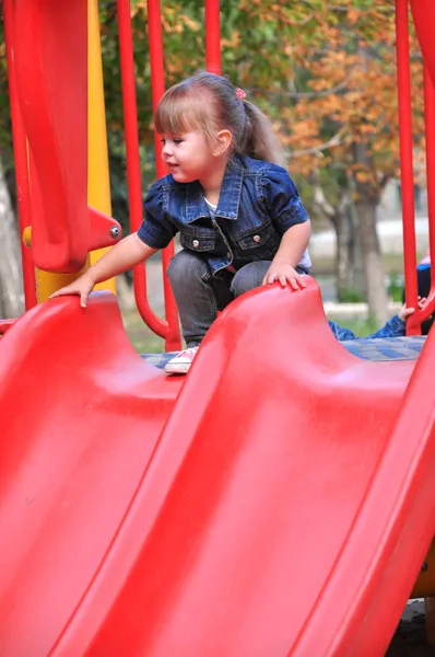 かわいい女の子の幼児がスライドに乗るつもりです。 — ストック写真