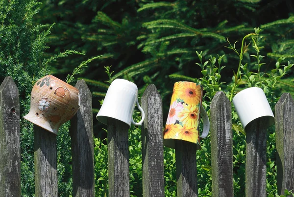 Cups on fence — Stock Photo, Image